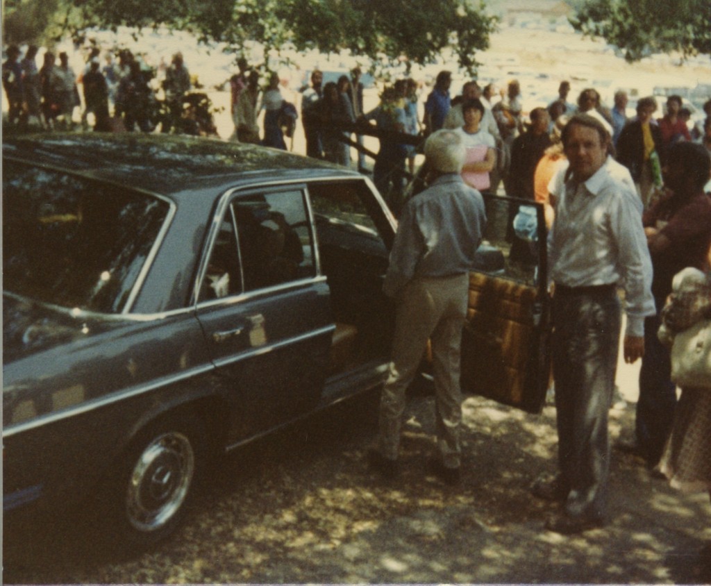 Alan Kishbaugh helping Krishnaji into the grey Mercedes in the Oak Grove after a talk. Copyright Reza Ganjavi.